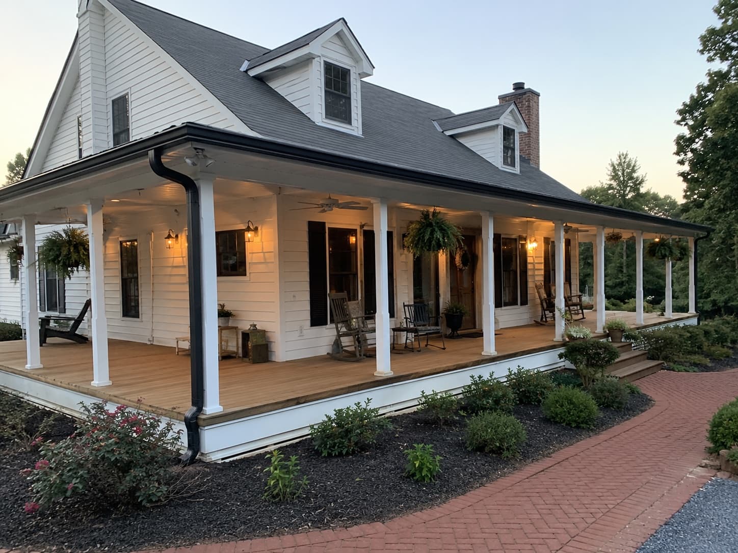White cape-cod farmhouse with full wraparound porch and dormers in Greer